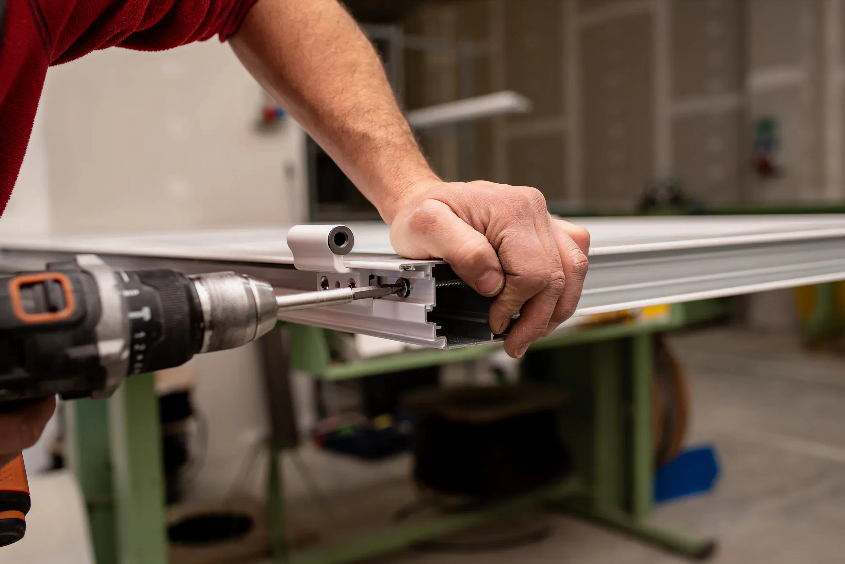 Technician repairing a storefront frame with a drill